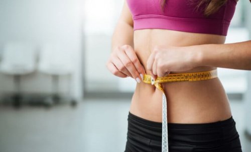 Kvinne måler midjen.