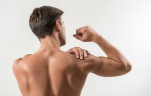 Ryggen til en mann som flekser sin arm.