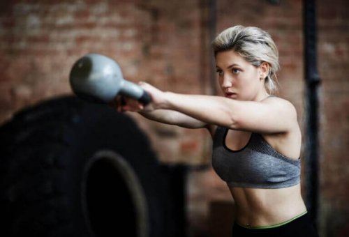 Kvinne som trener med kettlebells.