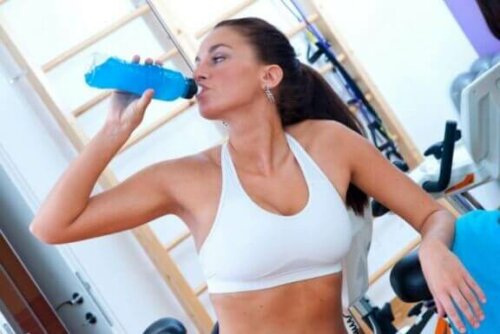 Kvinne drikker en isotonisk drikke