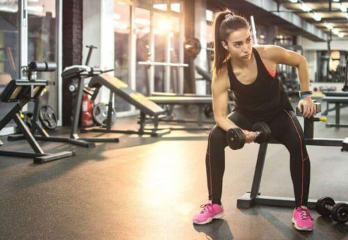 kvinne på benk med hantel