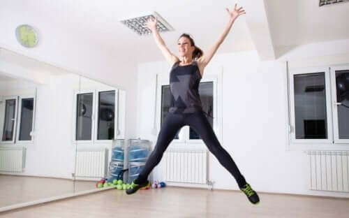 En kvinne som gjør stjernehopp hjemme.