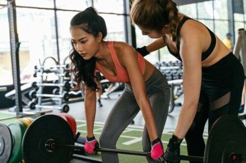 En personlig trener som underviser en nybegynner, slik at hun kan unngå de vanlige feilene ved markløft