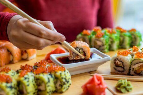 Person dypper sushi i soyasaus