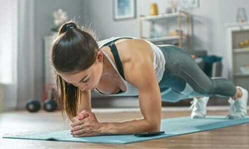 En kvinne som gjør planken som en del av hjemmetreningsrutinen sin.