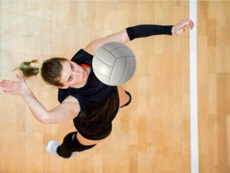 En kvinne som slår ballen på en innebane