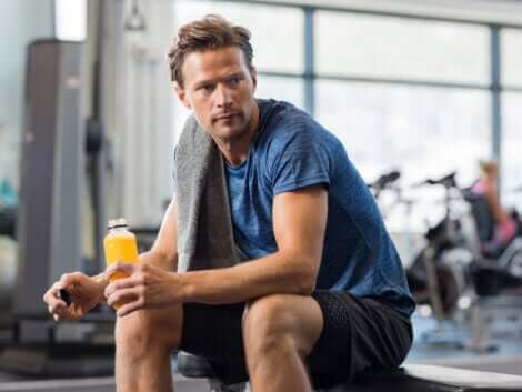 En mann som hviler mellom repetisjonene i treningsstudioet.